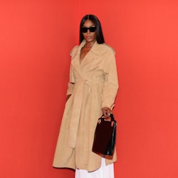 Naomi Campbell posing for a photo in a light brown coat at Milan Fashion Week