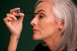 A woman applying mascara with an accessible applicator