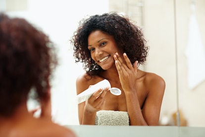 Woman applying sunscreen in the mirror