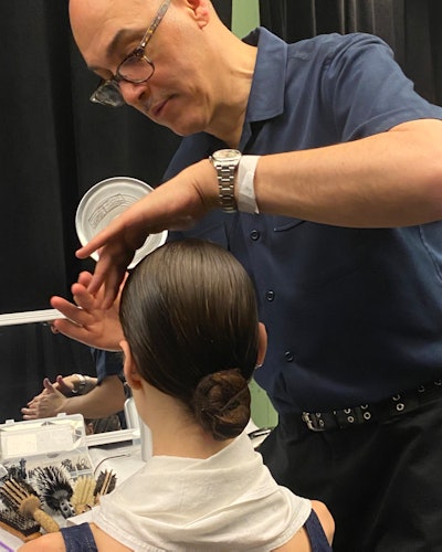 Olaplex Ambassador Jimmy Paul styling a model's hair backstage at Jason Wu F/W ‘23.