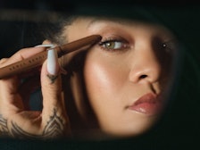 Rihanna applying Fenty Beauty Shadowstix to eye