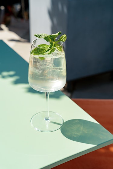 Single glass with iced summer lemonade with mint leaf on the table