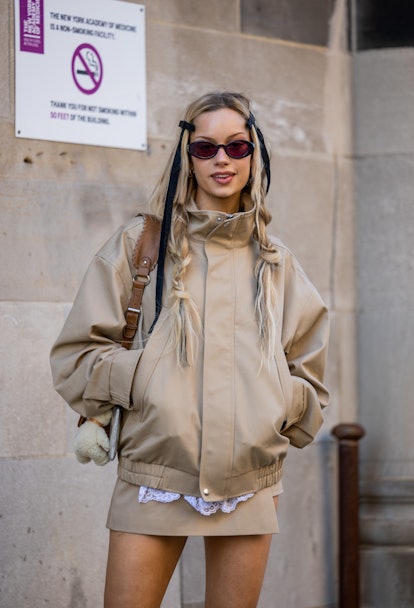 A guest wears brown beige jacket, skirt, bag outside Sandy Liang during New York Fashion Week on Feb...