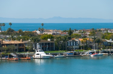 "A view of Newport Harbor in Newport Beach, CA, with Balboa Island in the Foreground, and the Ocean ...