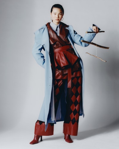 Model wearing Ellery coat, jacket, shirt, pants; IPPOLITA earrings; Neous boots.